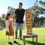 Man & Girl Playing A Wooden Game Outside