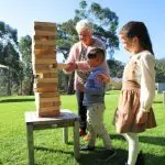 Family Playing With A Stack Of Wooden Blocks
