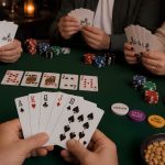Cards in hand with poker table in background