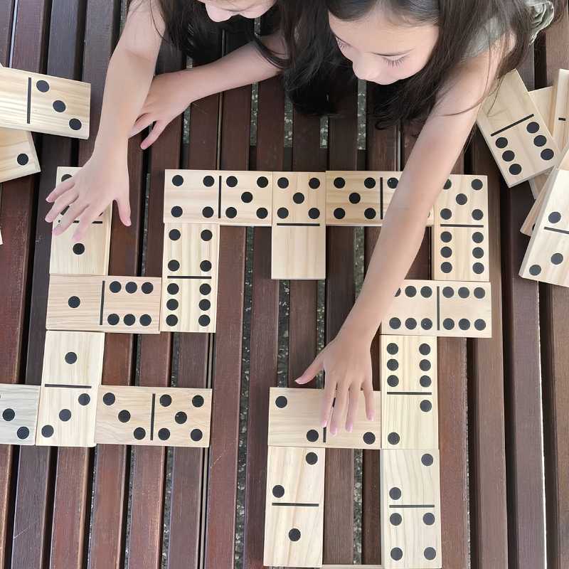 two girls playing giant dominoes