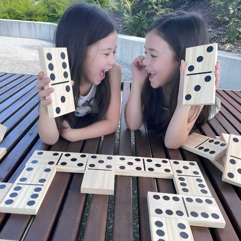 two girls laughing and playing dominoes