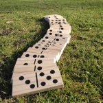 a row of giant wooden dominoes on grass