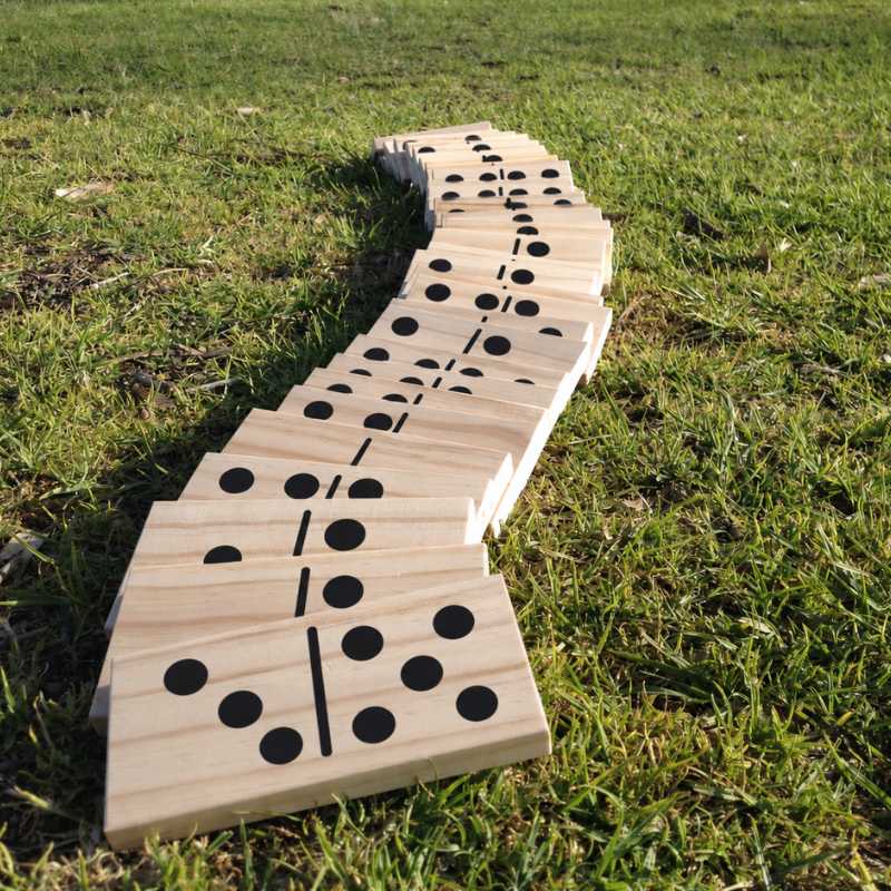 a row of giant wooden dominoes on grass