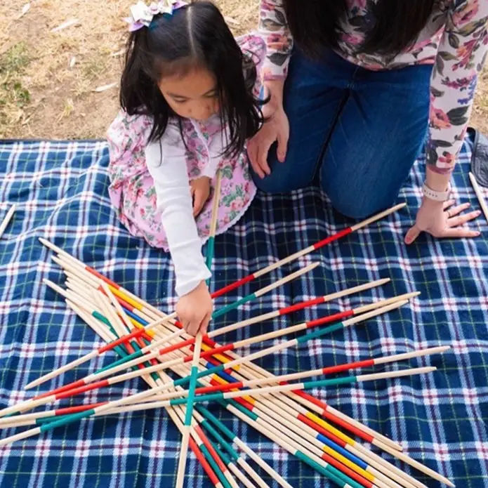 a girl and woman playing with sticks