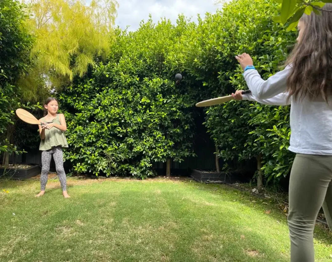 Girls Hitting A Black Ball In The Backyard