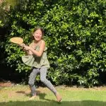 Girl Holding A Wooden Bat in backyard