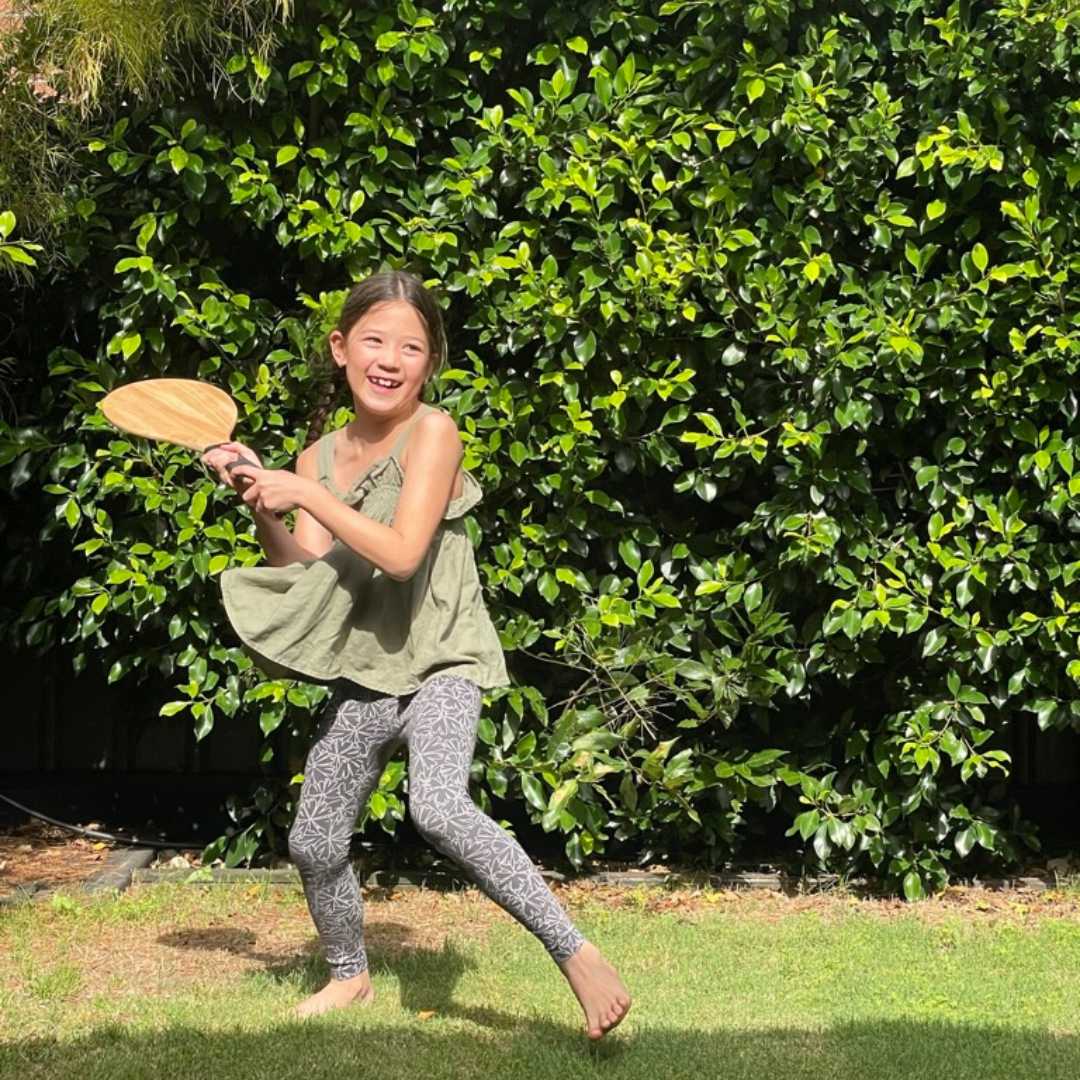 Girl Holding A Wooden Bat in backyard