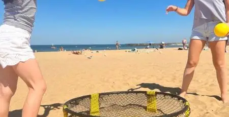 Beach games with lady and girl playing smash ball on beach